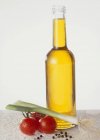 Vista close-up de uma garrafa de óleo com legumes — Fotografia de Stock