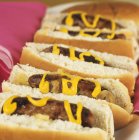 Hot dogs with mustard and onions — Stock Photo
