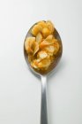 Pumpkin seeds on spoon on white surface — Stock Photo
