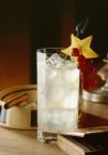 Nahaufnahme von Cocktail mit Eis, Sternenscheibe, roten Johannisbeeren und Zigarre auf Aschenbecher — Stockfoto