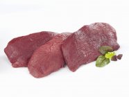 Closeup view of raw ostrich meat pieces with herbs — Stock Photo