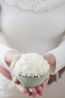 Mains féminines tenant cupcake — Photo de stock