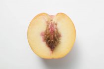 Half peach with stone — Stock Photo