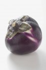 Round aubergine with drops of water — Stock Photo