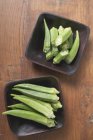 Whole and halved okra pods — Stock Photo