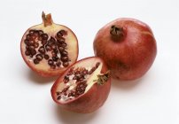 Ganze und halbierte Granatäpfel — Stockfoto