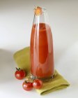 Home-made tomato ketchup in bottle over green towel  on white surface — Stock Photo
