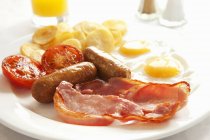 Englisches Frühstück mit Speck und Eiern auf weißem Teller — Stockfoto