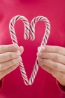Woman holding two candy canes — Stock Photo