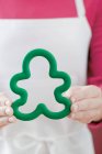 Woman in apron holding green cookie cutter — Stock Photo