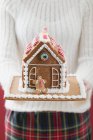 Woman holding gingerbread house — Stock Photo