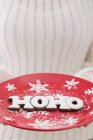 Крупный план обрезанный вид лица, держащего праздничную тарелку со словом hoho — стоковое фото