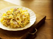Egg tagliatelle pasta with peas — Stock Photo