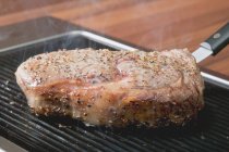 Grilling peppered steak — Stock Photo