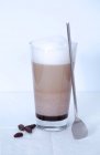 Vista de cerca de Caffe moca con leche espumosa, cuchara y frijoles - foto de stock