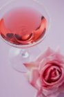 Closeup view of rose liqueur in glass with sugared rim and rose beside — Stock Photo