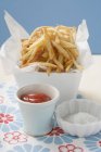 Potato fries in dish with ketchup and salt — Stock Photo