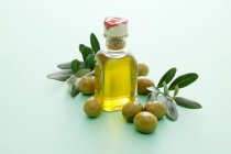 Бутылка оливкового масла с оливками — стоковое фото