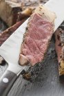 Rib eye steak on knife — Stock Photo