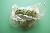 Alcachofas en bolsa de plástico - foto de stock