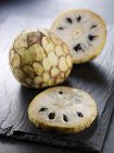 Frische ganze und in Scheiben geschnittene Cherimoya-Früchte — Stockfoto