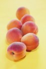 Several apricots on yellow — Stock Photo