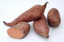 Ganze und halbierte Süßkartoffeln — Stockfoto