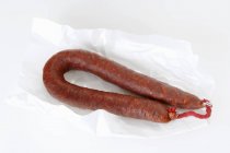 Closeup view of Chorizo sausage on white paper — Stock Photo