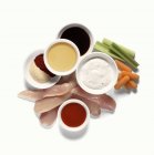 Pollo sin cocer con condimentos y verduras en la superficie blanca - foto de stock