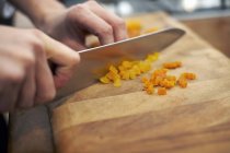 Human hand Dicing dried apricots — Stock Photo