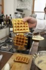 Freshly baked waffles in chef hand — Stock Photo