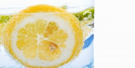Склянка води зі скибочками лимона — стокове фото