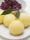 Красная капуста и картофельные пельмени на белой тарелке — стоковое фото