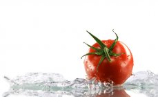 Красный помидор, окруженный водой — стоковое фото