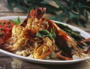 Camarão e lagostim sobre batatas em prato branco — Fotografia de Stock