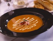 Closeup view of lobster Bisque soup in black bowl — Stock Photo