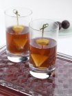Vista da vicino di due bicchieri con bevande alla frutta sul vassoio — Foto stock