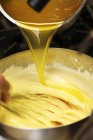 Adding clarified butter to Hollandaise sauce — Stock Photo