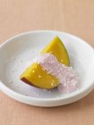 Крупним планом шматочок манго з полуничним йогуртом і подрібненим кокосовим горіхом — стокове фото