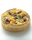 Closeup view of whole fruit torte on white surface — Stock Photo