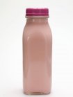 Primo piano vista di salsa rosa in bottiglia di vetro su superficie bianca — Foto stock