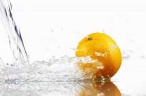 Апельсин з розбризкувальною водою — стокове фото