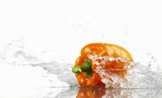 Pimenta laranja com água salpicante — Fotografia de Stock