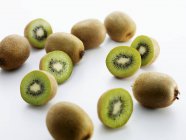 Frutas de kiwi inteiras e cortadas pela metade — Fotografia de Stock