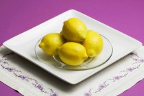 Zitronen auf einem Glasteller — Stockfoto
