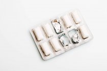 Nahaufnahme von Kaugummipellets in Verpackungen auf weißer Oberfläche — Stockfoto
