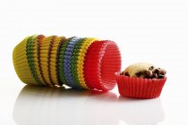 Muffin and colored paper cases — Stock Photo