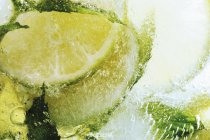 Limes in block of ice — Stock Photo