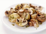 Смажені гриби з часником і трав'яним маслом на білій тарілці — стокове фото
