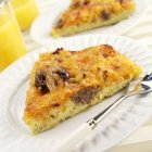 Closeup view of mushroom sausage Frittata slices on white plates with fork — Stock Photo
